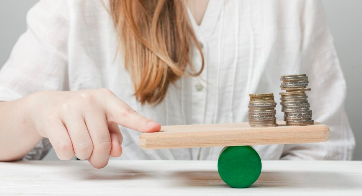 mujer-sosteniendo-su-dedo-en-equilibrio-con-las-monedas